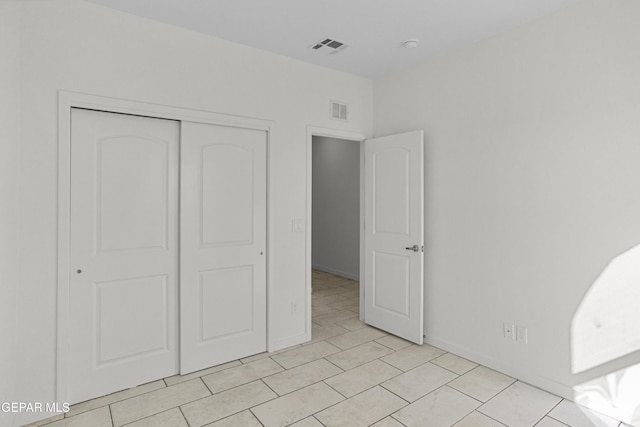 unfurnished bedroom featuring a closet and light tile patterned floors