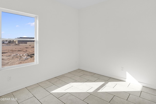 tiled spare room featuring plenty of natural light