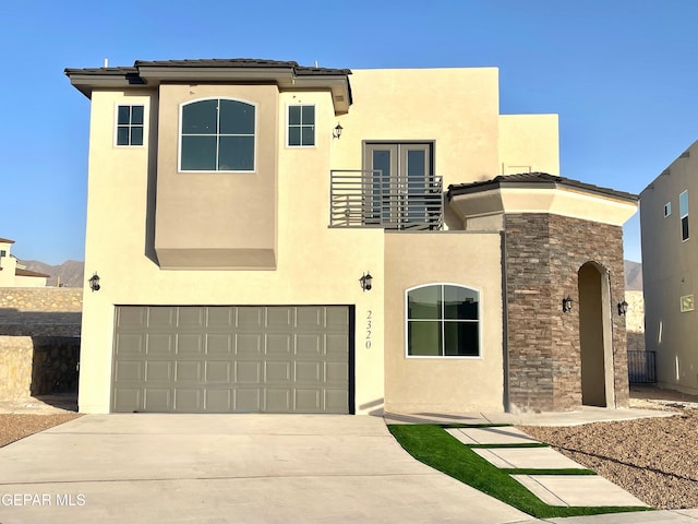 view of front of property with a garage, french doors, and a balcony