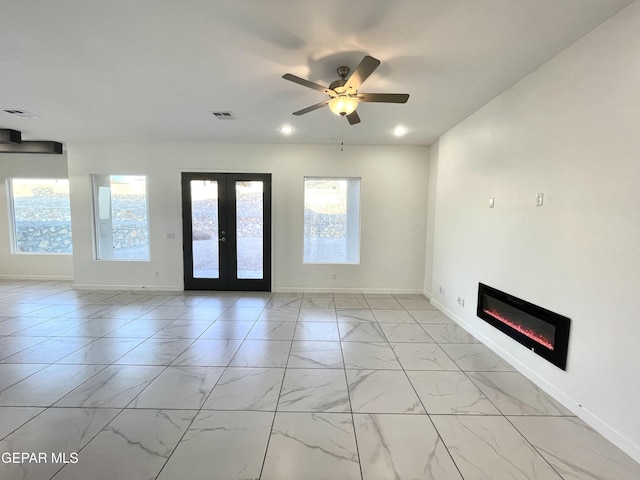 unfurnished living room with ceiling fan and french doors