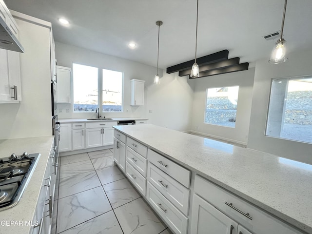 kitchen with white cabinets, extractor fan, decorative light fixtures, sink, and stainless steel gas stovetop