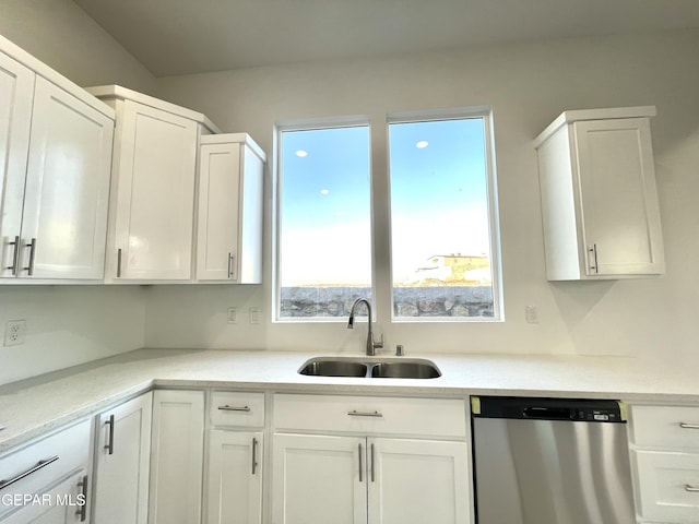 kitchen with stainless steel dishwasher, white cabinets, and sink