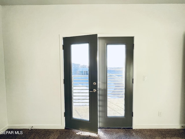 entryway featuring french doors and dark colored carpet