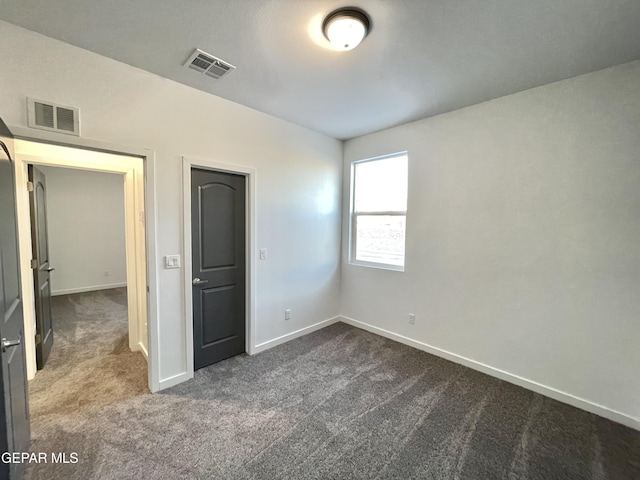 unfurnished bedroom featuring dark colored carpet