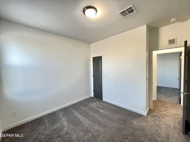 empty room with dark colored carpet