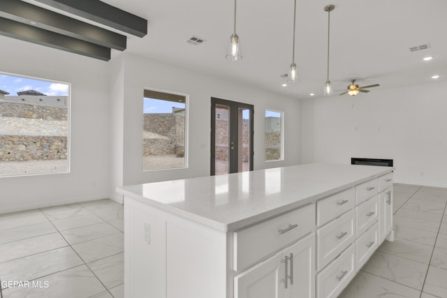 kitchen with white cabinetry, french doors, a kitchen island, and a wealth of natural light