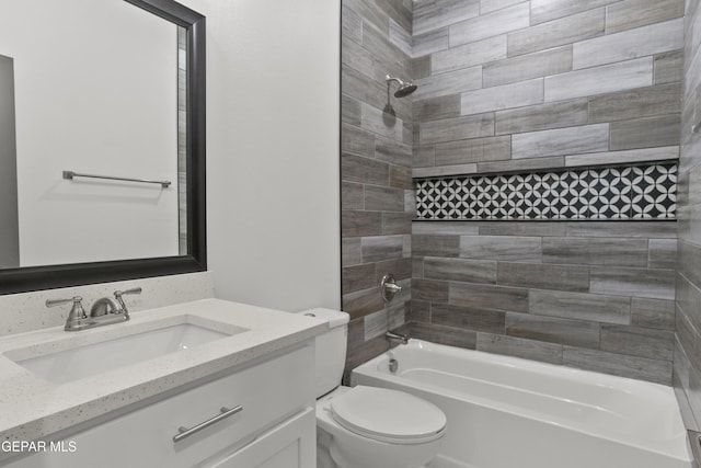 full bathroom with vanity, tiled shower / bath combo, and toilet