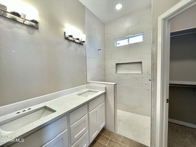 bathroom featuring vanity, tile patterned floors, and tiled shower