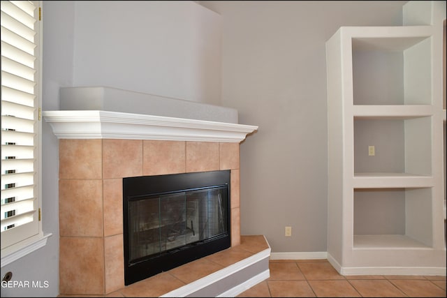 details featuring a tile fireplace and built in shelves