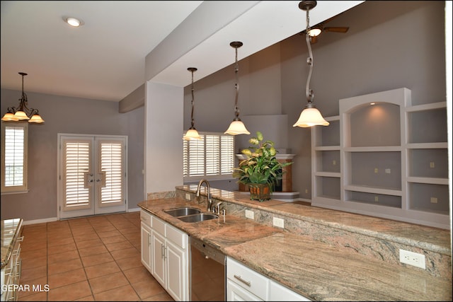 kitchen featuring dishwasher, sink, built in shelves, light tile patterned flooring, and white cabinetry