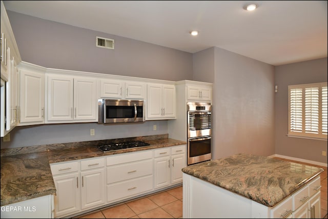 kitchen featuring white cabinets, light tile patterned floors, and appliances with stainless steel finishes