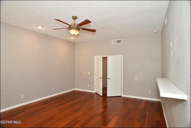 empty room with ceiling fan and dark wood-type flooring