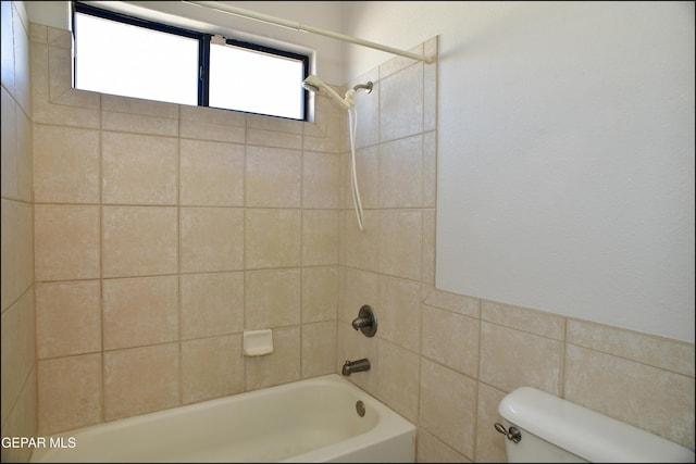 bathroom featuring toilet and tiled shower / bath