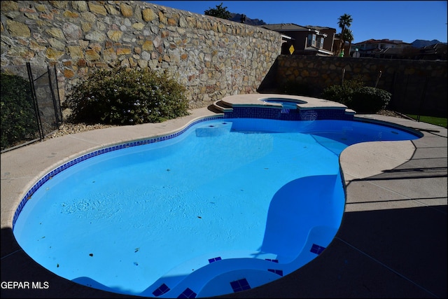 view of swimming pool featuring an in ground hot tub