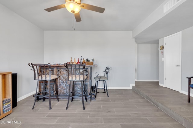 dining area featuring bar and ceiling fan