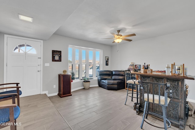 living room featuring bar area and ceiling fan