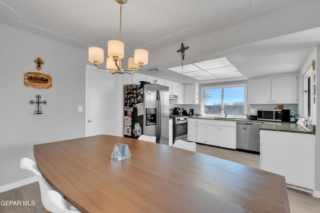 dining area featuring sink and a chandelier