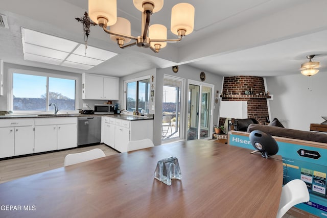 kitchen featuring a wealth of natural light, white cabinetry, hanging light fixtures, and stainless steel appliances