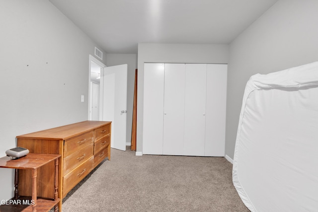 bedroom with light carpet and a closet