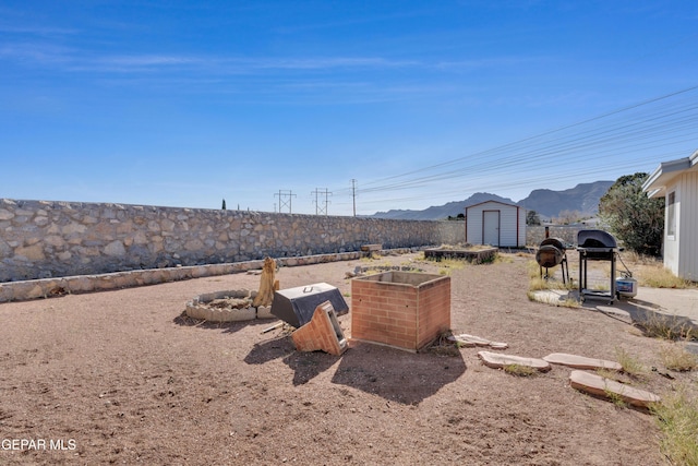 view of yard featuring a mountain view and a storage shed