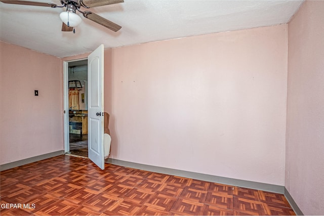 unfurnished room featuring ceiling fan, dark parquet flooring, and a textured ceiling