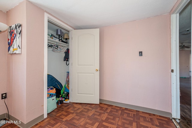 unfurnished bedroom featuring dark parquet flooring and a closet