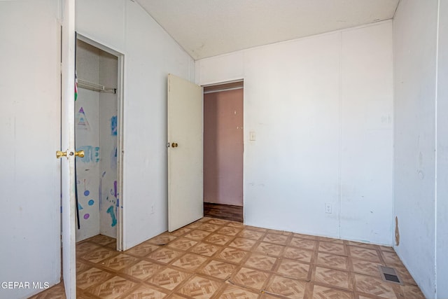 unfurnished bedroom with light parquet floors, vaulted ceiling, and a closet