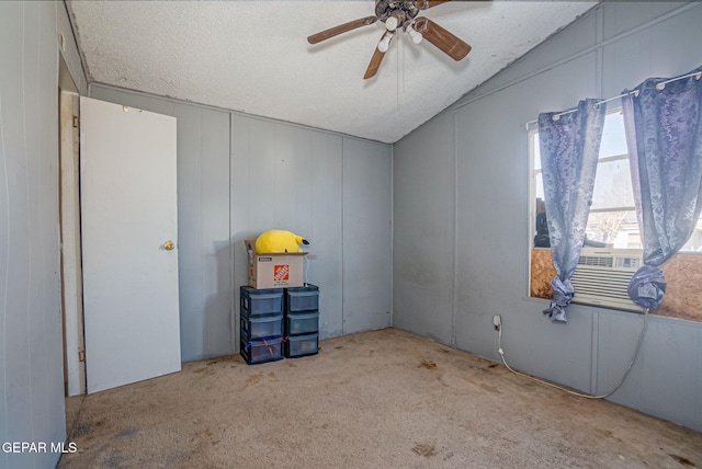 carpeted empty room with ceiling fan, cooling unit, a textured ceiling, and vaulted ceiling