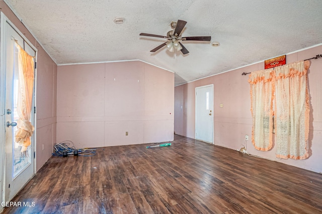 interior space featuring dark hardwood / wood-style floors, ceiling fan, a textured ceiling, and vaulted ceiling