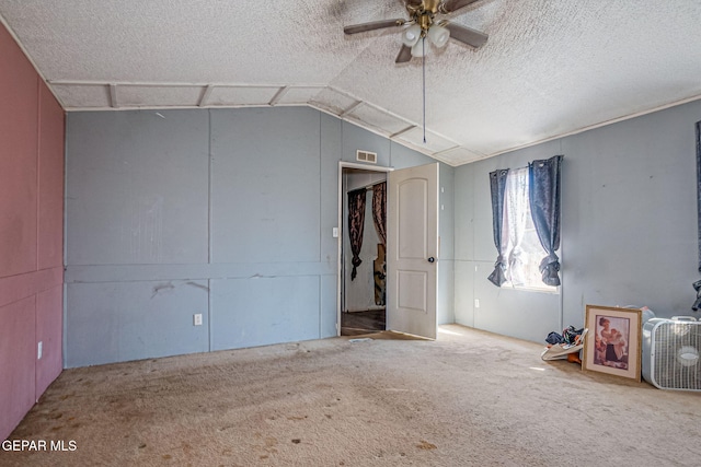 unfurnished bedroom featuring a textured ceiling, ceiling fan, carpet, and lofted ceiling