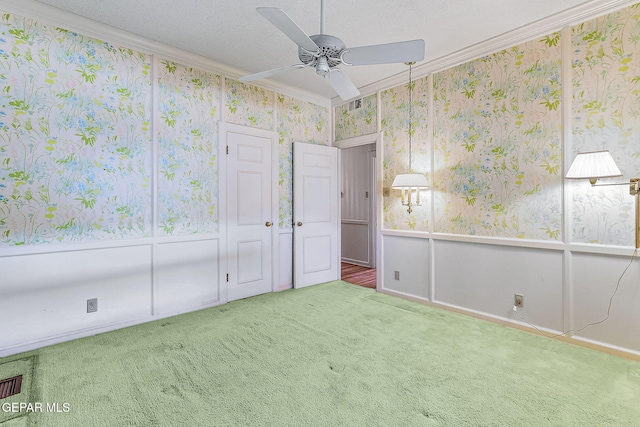 unfurnished bedroom featuring carpet flooring, ceiling fan, a textured ceiling, and ornamental molding