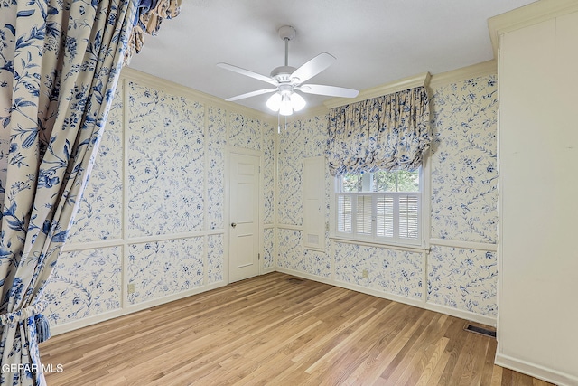 spare room featuring ceiling fan, wood-type flooring, and ornamental molding