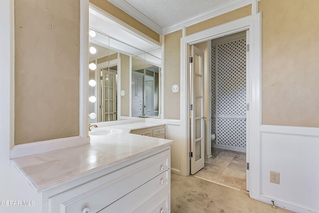 bathroom featuring crown molding, vanity, and a textured ceiling