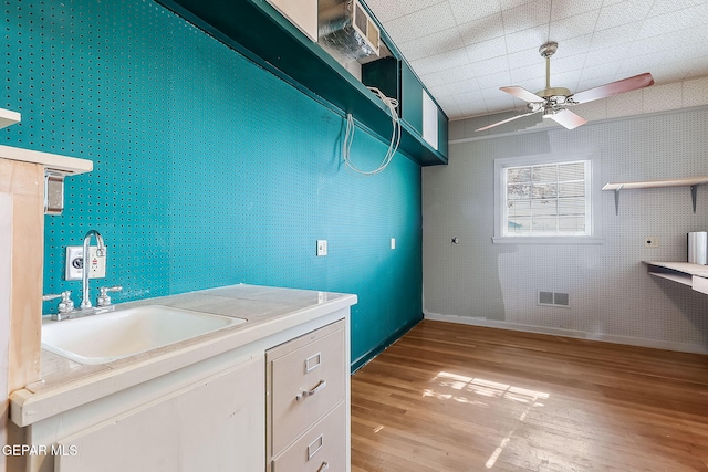 laundry area featuring hardwood / wood-style flooring, ceiling fan, and sink