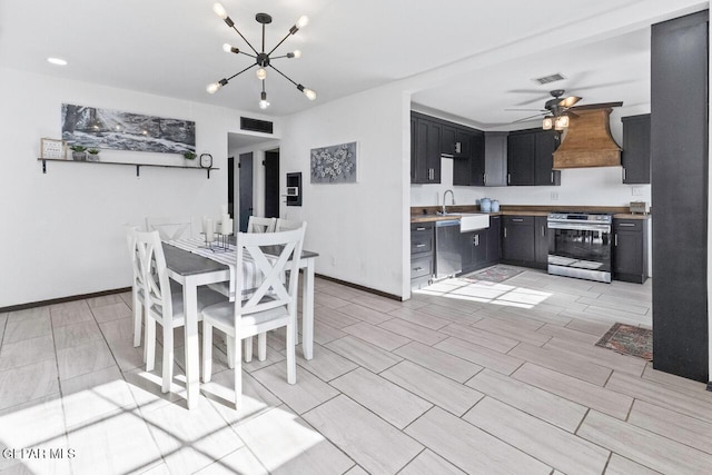 dining room with sink and ceiling fan with notable chandelier