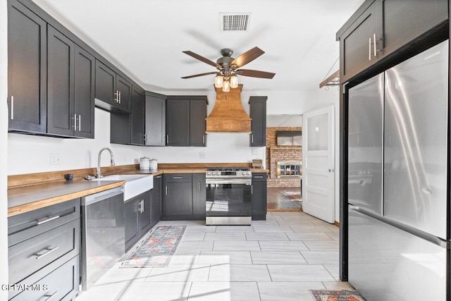 kitchen with ceiling fan, sink, stainless steel appliances, and wooden counters