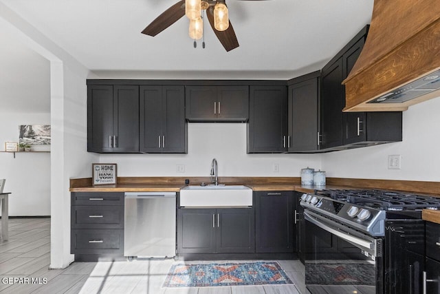 kitchen with custom exhaust hood, sink, ceiling fan, appliances with stainless steel finishes, and butcher block counters