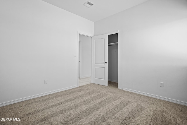 unfurnished bedroom featuring light colored carpet and a closet