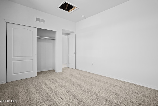 unfurnished bedroom with light carpet and a closet