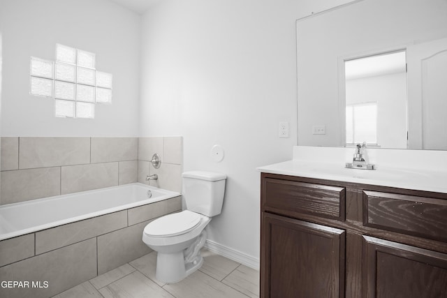 bathroom featuring vanity, toilet, and tiled tub