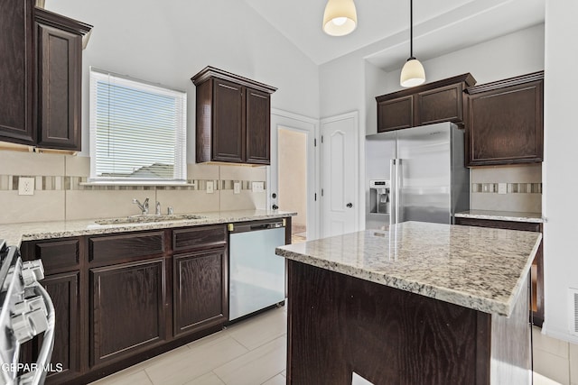 kitchen featuring decorative backsplash, stainless steel appliances, sink, pendant lighting, and a center island