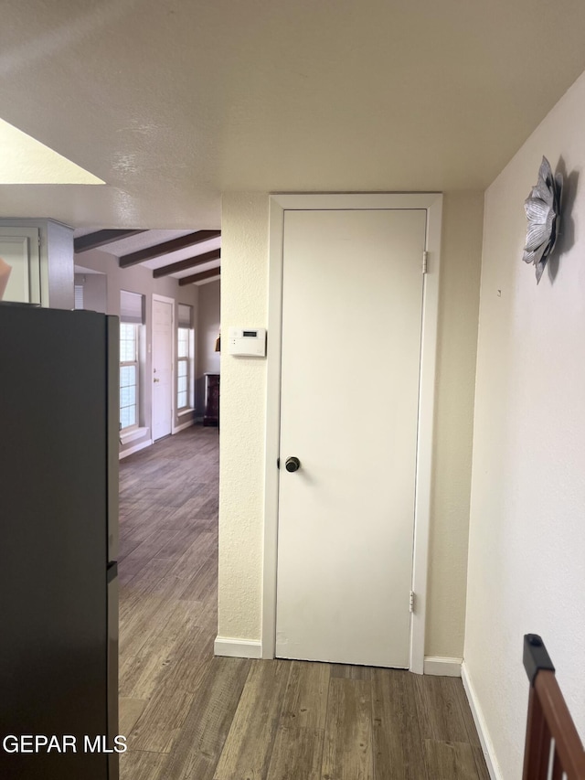 corridor with beam ceiling and dark hardwood / wood-style flooring