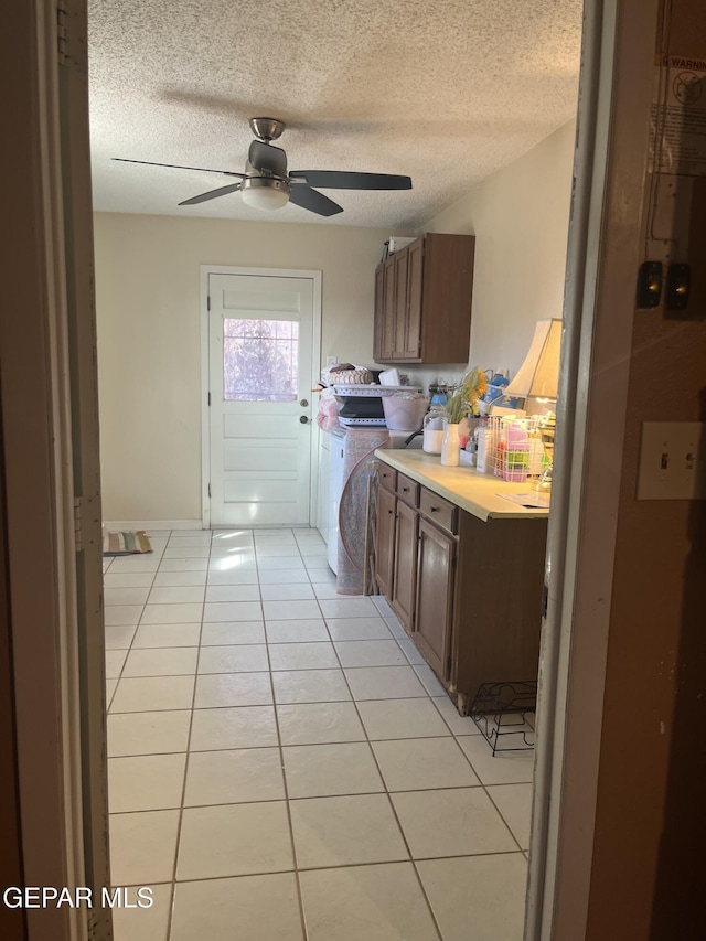 kitchen featuring a textured ceiling, ceiling fan, and light tile patterned flooring