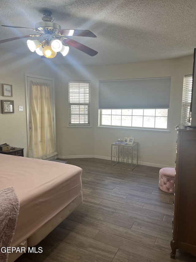 bedroom featuring ceiling fan, wood-type flooring, and a textured ceiling