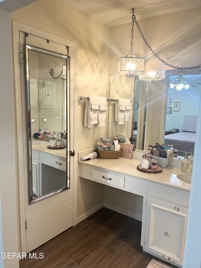 bathroom featuring ceiling fan, hardwood / wood-style floors, vanity, and a textured ceiling