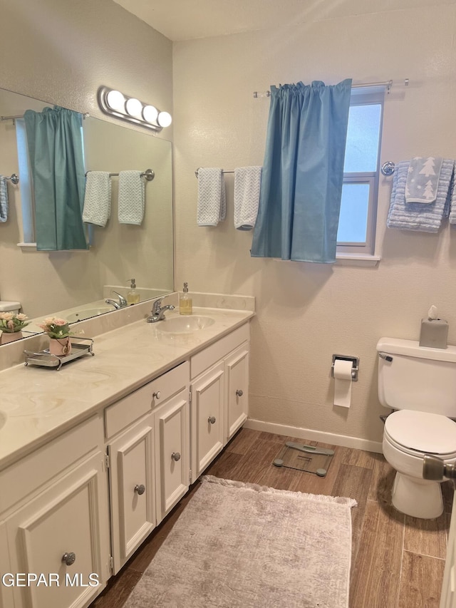 bathroom with hardwood / wood-style floors, vanity, and toilet