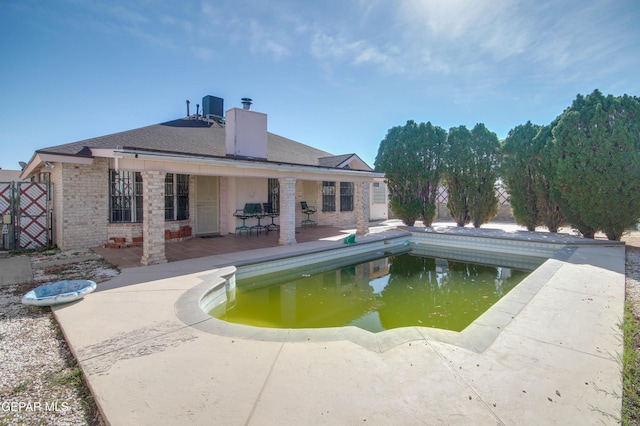 view of swimming pool featuring central air condition unit and a patio