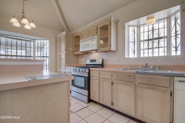 kitchen featuring white appliances, a healthy amount of sunlight, sink, pendant lighting, and a chandelier