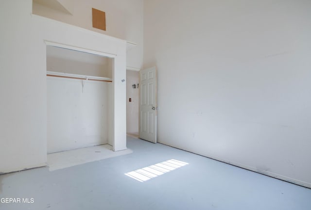 unfurnished bedroom with a high ceiling and a closet