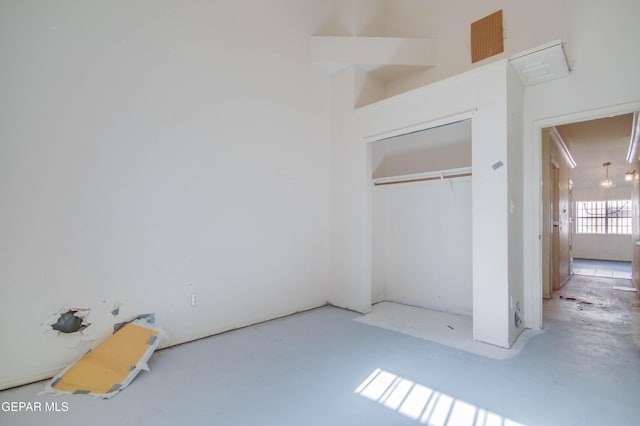 unfurnished bedroom featuring concrete flooring and a closet